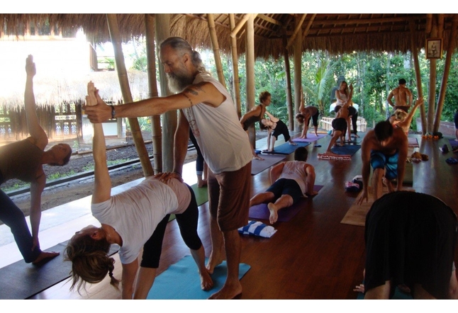 man with beard teaching a yoga class adjustment Yoga Studios Ubud Classes Practice Bali