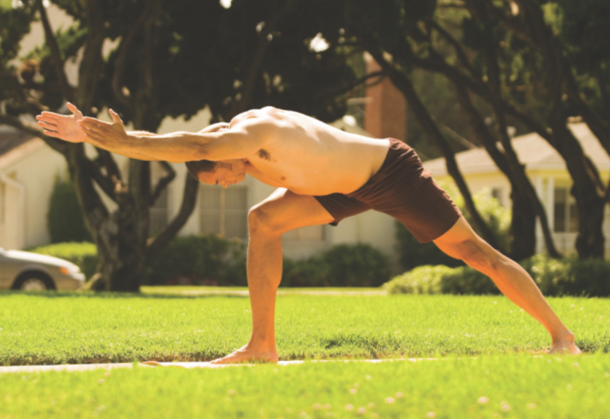 Man preparing for Warrior 3 Pose from Warrior 1 stance with arms reaching forward