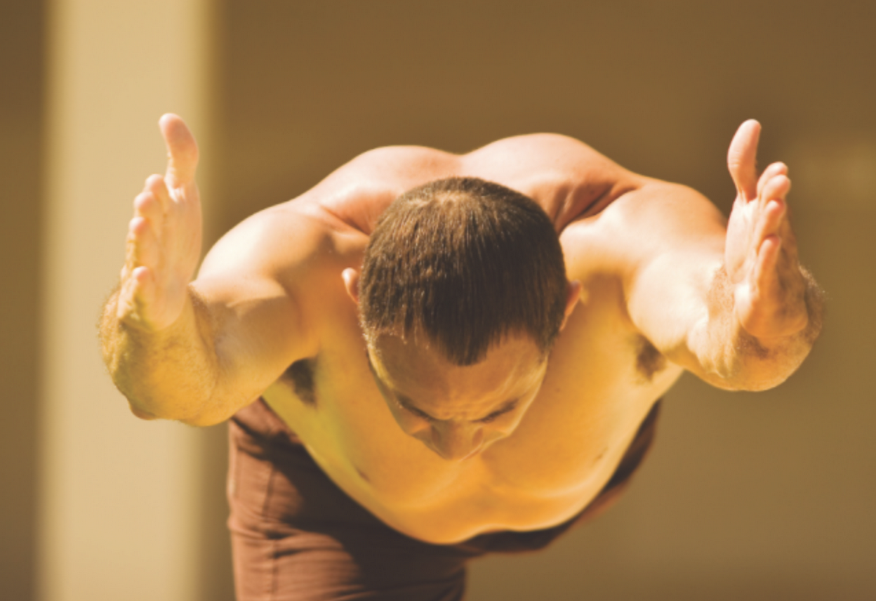 Man preparing for Warrior 3 Pose from Warrior 1 stance with arms reaching forward