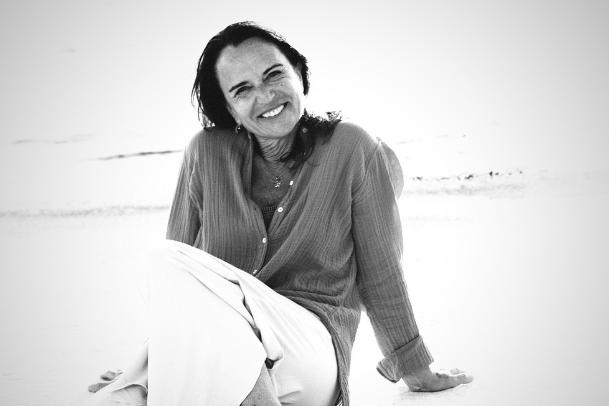 Andrea Lutz smiling on a quiet beach, Ashtanga yoga teacher portrait