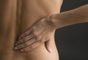 Man holding his lower back illustrating back pain after yoga and chronic lower back discomfort