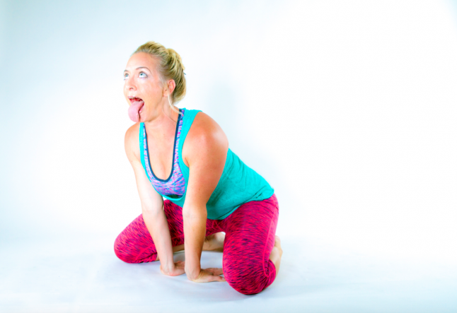 blonde woman red pants blue top lion pose simhasana