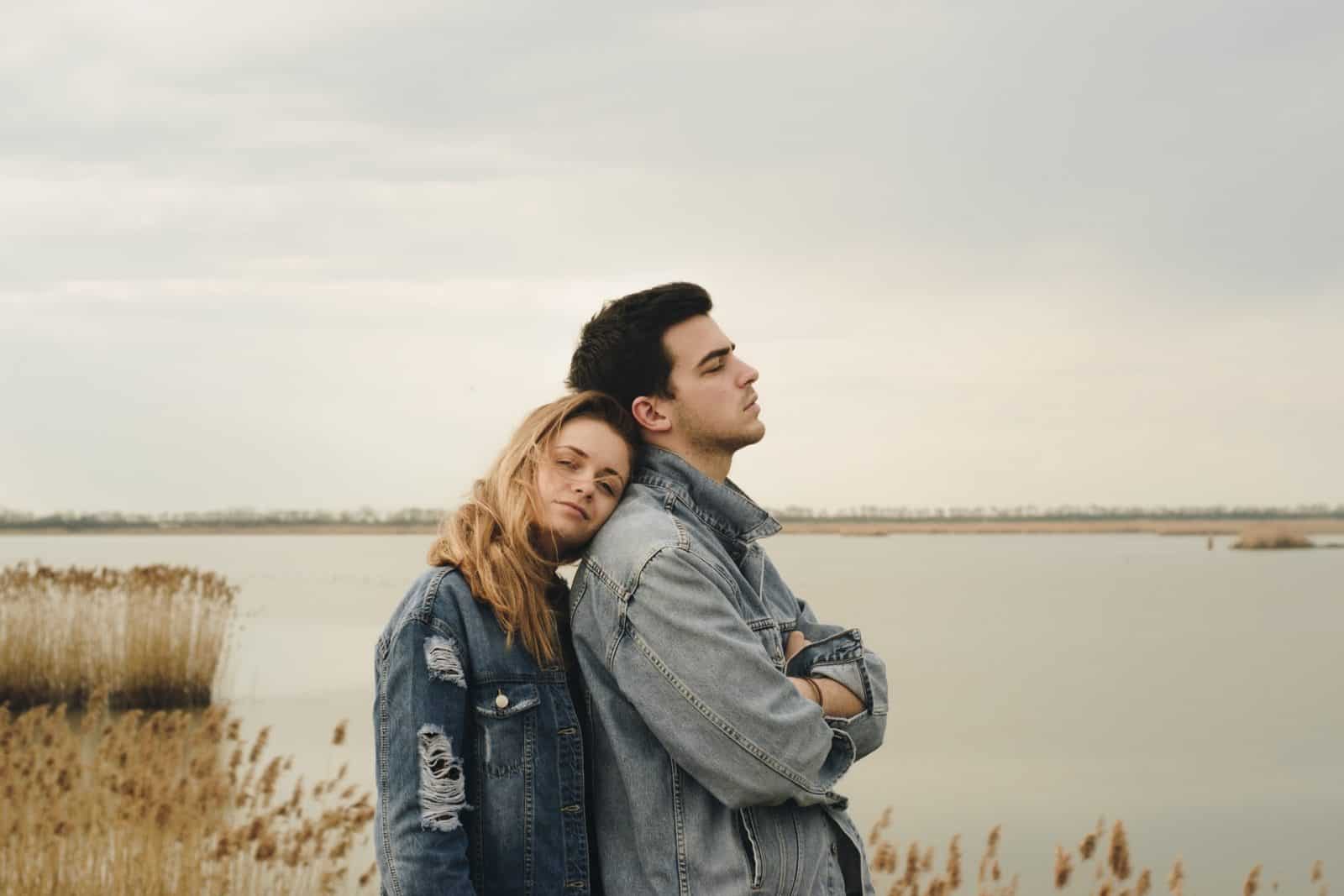 couple in conflict not looking at each other, back to back, outdoor