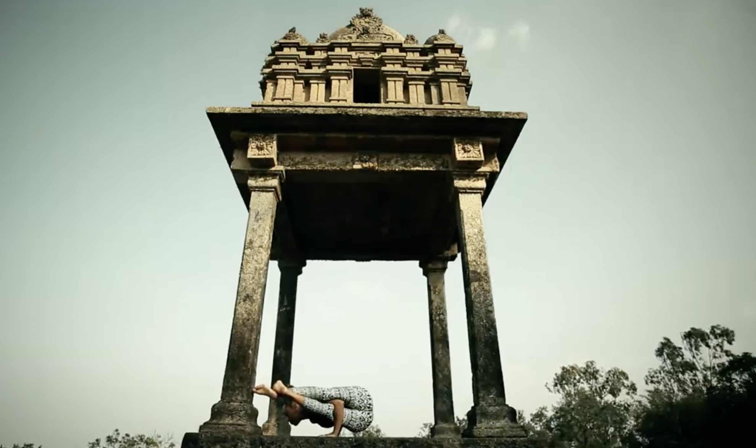 woman doing yoga in front of temple