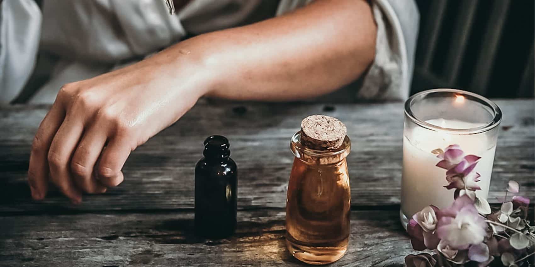 woman's arm on wooden table with bottles tinctures, drops CBD oil buy healthy natural pain alzheimer