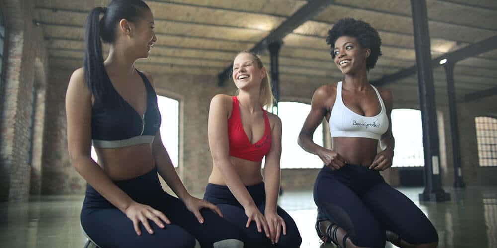 three women sitting down laughing empty office room workplace yoga tips teachers