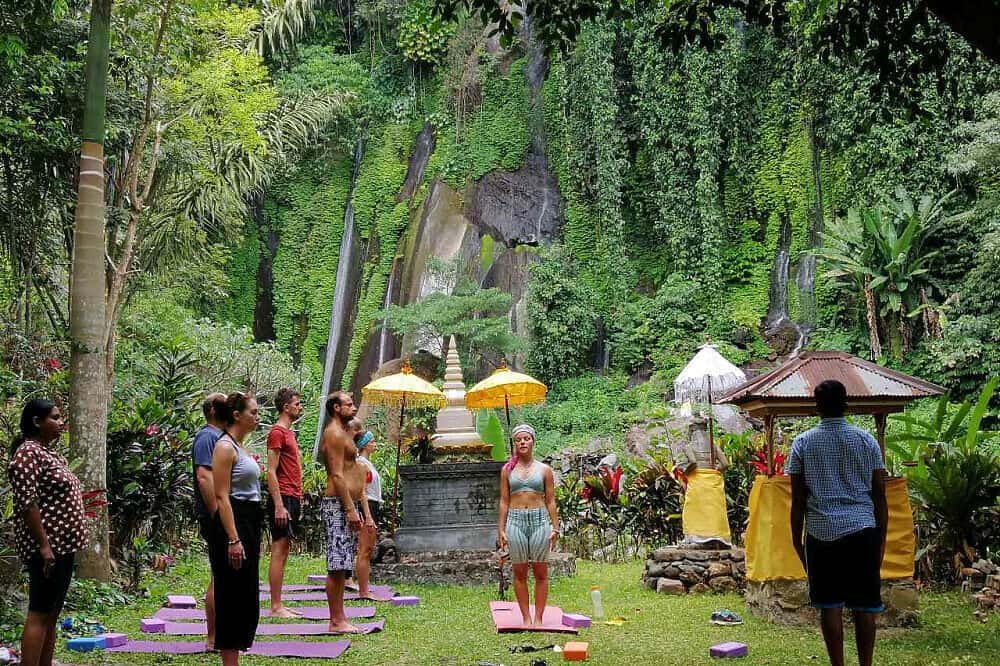 jungle ceremony three women walking on beach with surf boards bali yoga retreats all inclusive ubud healing meditation spa nudes Indonesia woman for couples resort surf and surfing vacation canggu