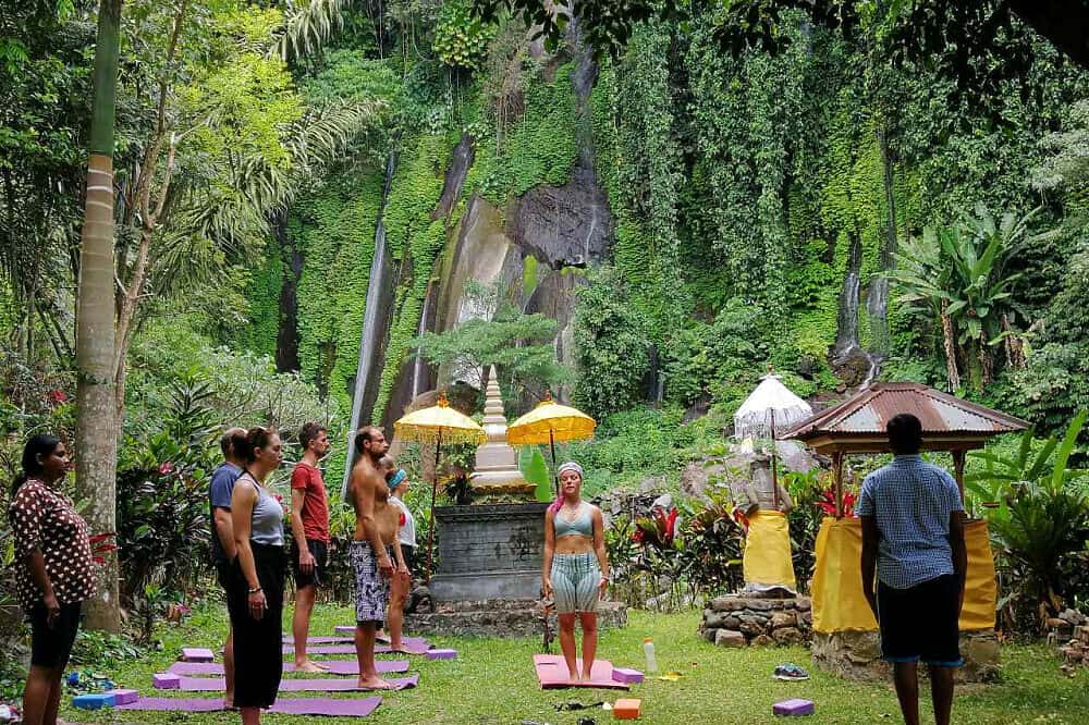 jungle ceremony three women walking on beach with surf boards bali yoga retreats all inclusive ubud healing meditation  spa nudes Indonesia woman  for couples resort surf and surfing vacation canggu