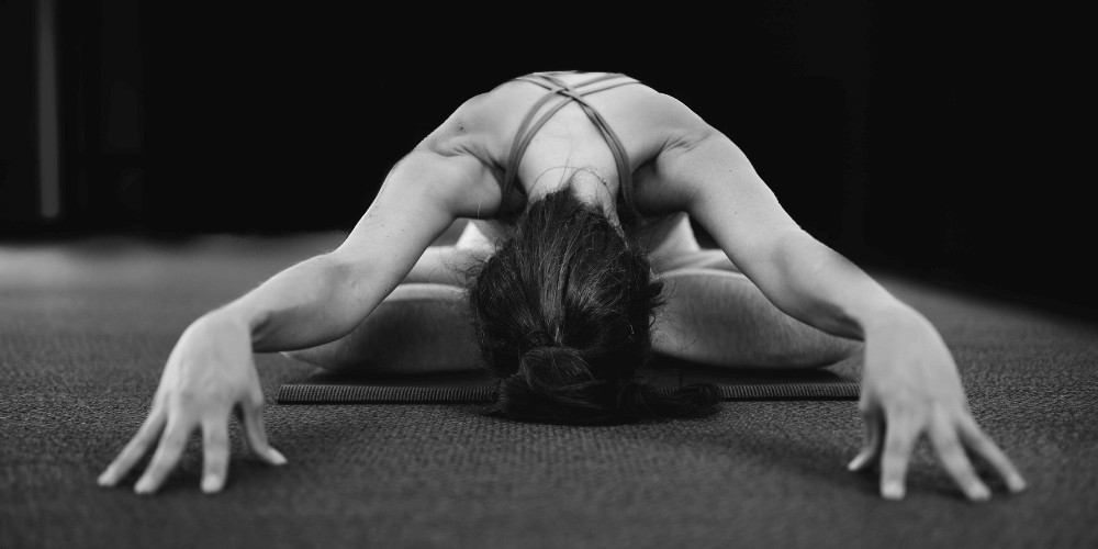 mujer haciendo una postura de yoga en el suelo   

formacion de yoga profesores