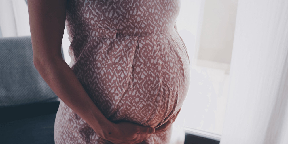 pink and white dress on a pregnant woman belly mother to be