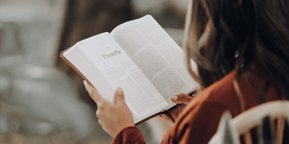 Mujer leyendo un libro sobre proverbios  yoga para pricipiantes en casa