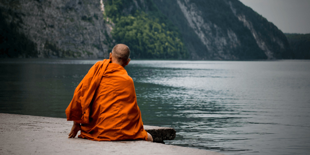 Monk vow of silence sitting infront of a lake vow of silence