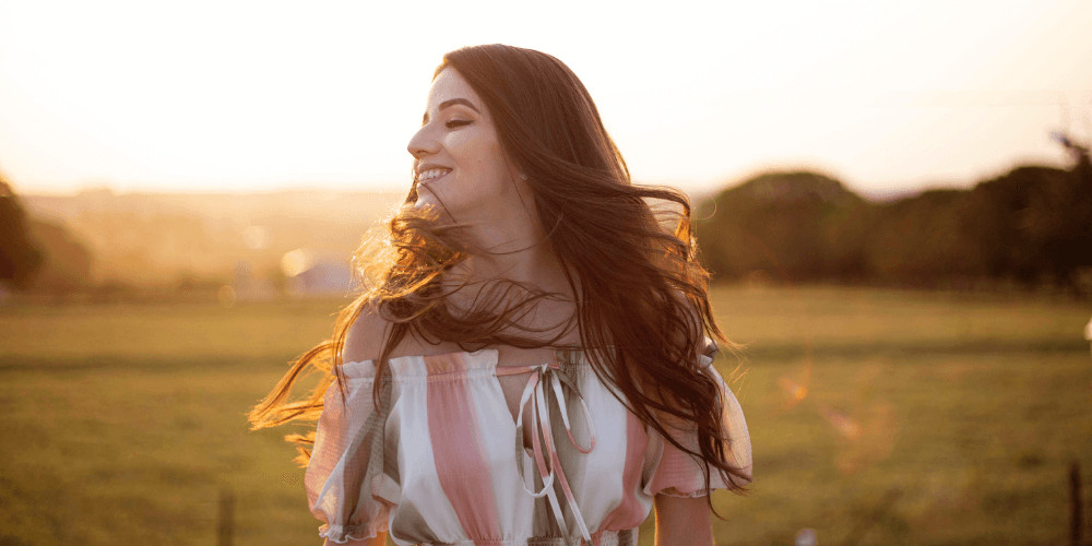 woman similing facing the sun, NLP certification techniques NLP life coach