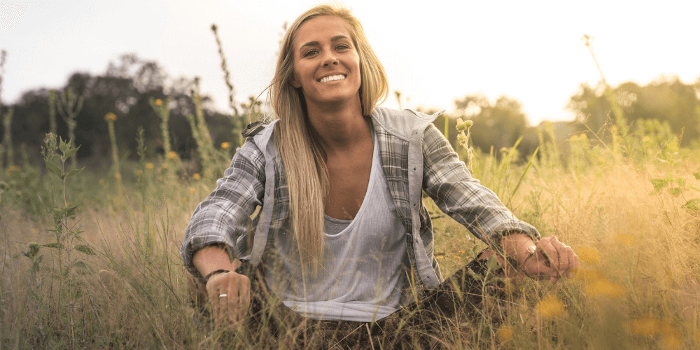 woman sitting on the grass while smiling