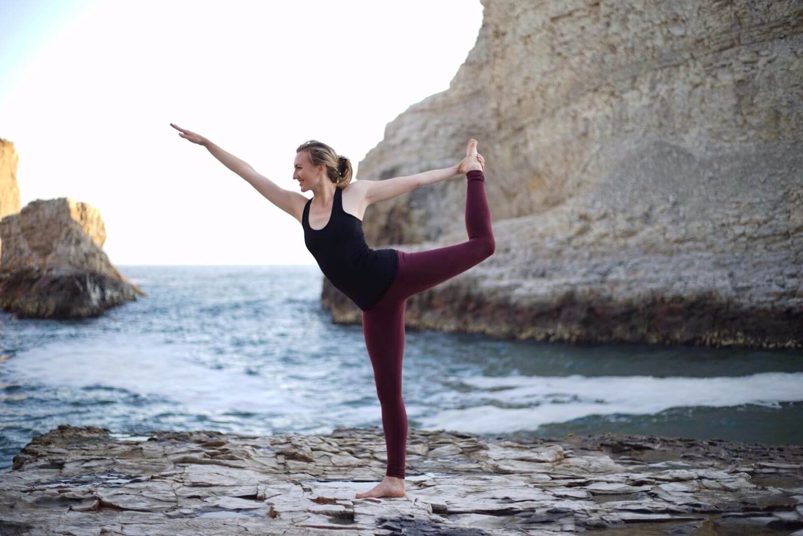 blonde woman by the beach red pants 