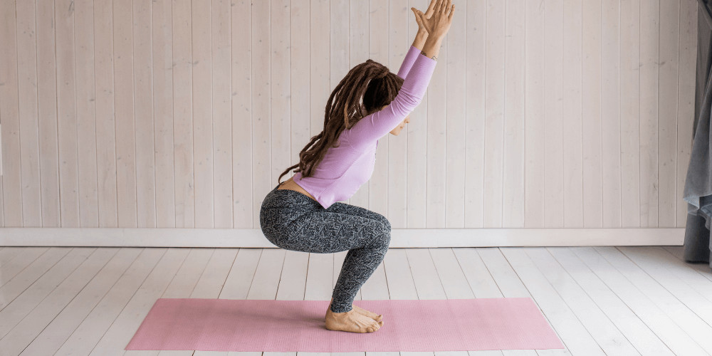 Girl doing chair pose.