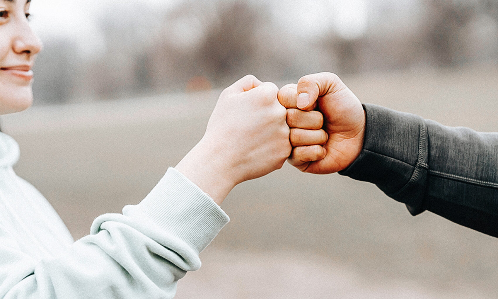 Two persons doing a friendly fist bump