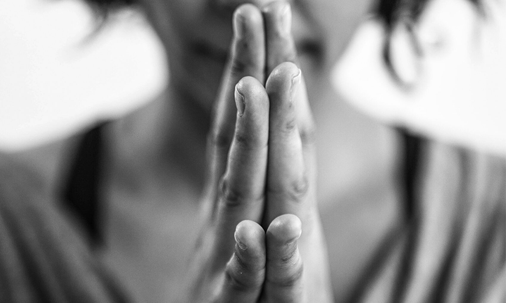 Mujer juntando las manos meditando o rezando