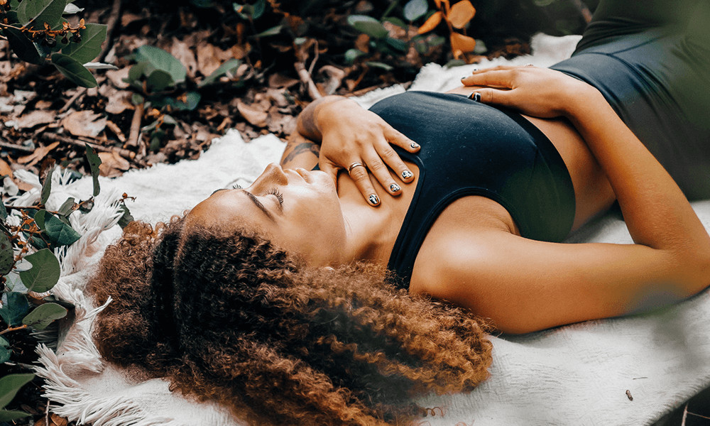 centering meditation woman sleeping in forrest on white blanket