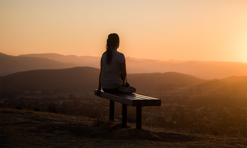 Sunset woman sitting on bench