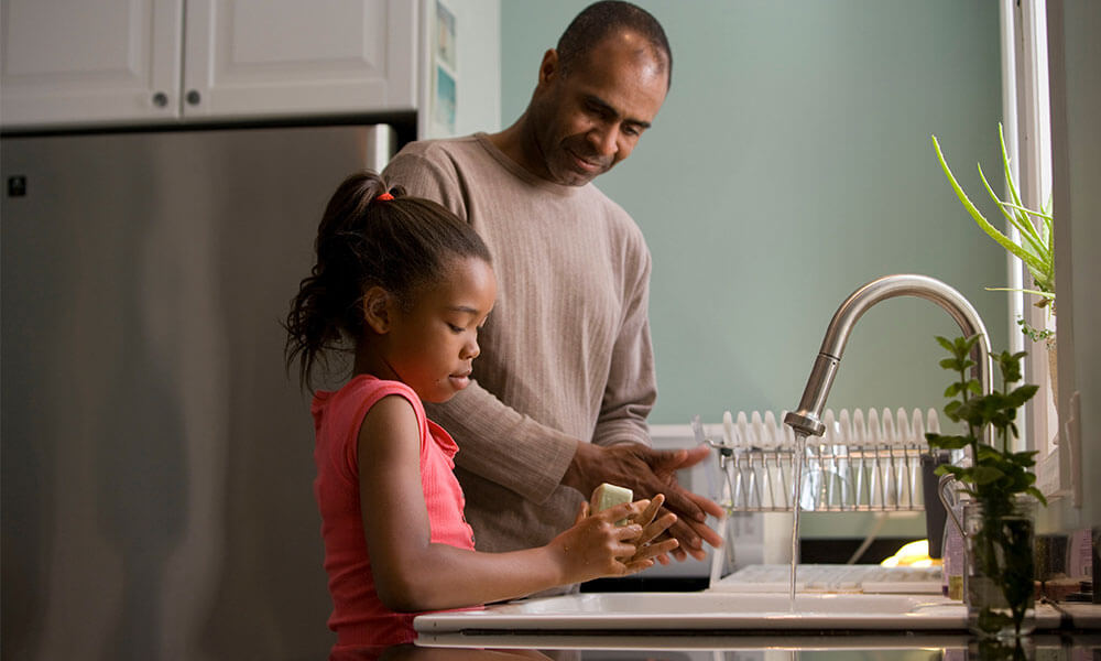 dad and daughter in kitchen serving water washing hands