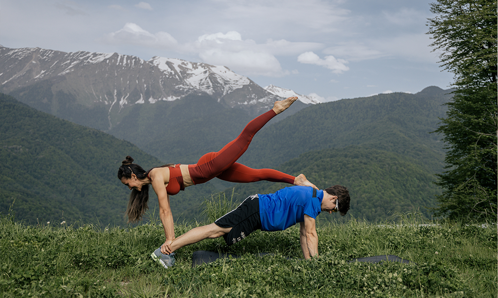 Two people doing acroyoga in the mountains. bff 2 person yoga poses
