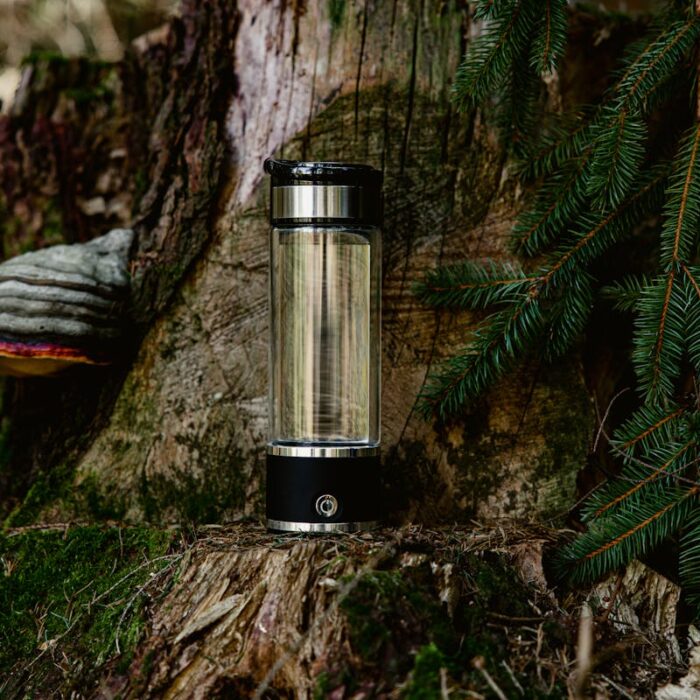 is hydrogen water good for your kidneys? Hydrogen water bottle outdoors with forest background symbolizing natural hydration and kidney health benefits