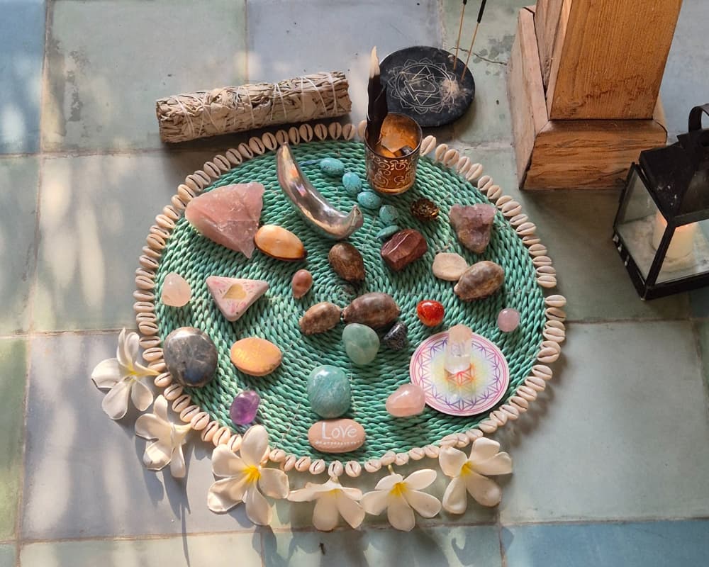 Flat lay of crystals, sage, and sacred objects arranged for a yoga retreat