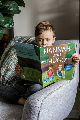 Young boy reading kids yoga storybook at home, showing how yoga for children promotes self-awareness and well-being through daily practice