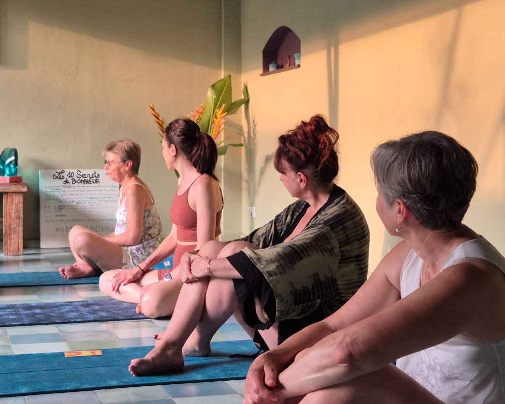 A diverse group of yoga practitioners seated in a studio, enjoying a tranquil and supportive learning environment