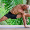 Yoga teacher Everett Nowell do yogi performing an intense asana surrounded by palm trees