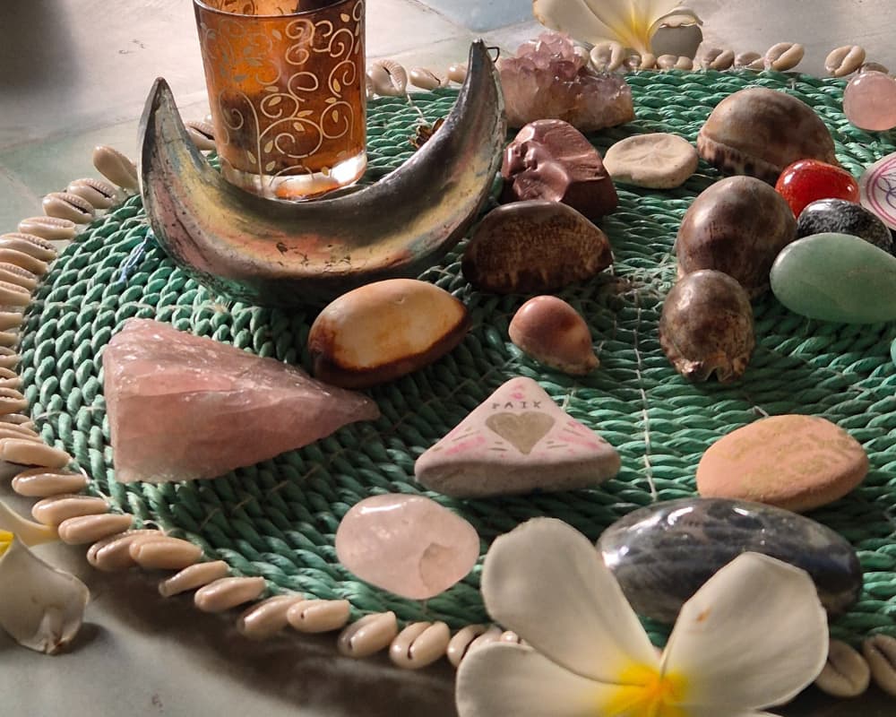 Healing stones and natural elements arranged on a woven mat, symbolizing mindfulness and energy work in yoga practice