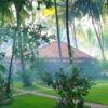 Yoga retreat center nestled in the jungle with palm trees and serene pathways.