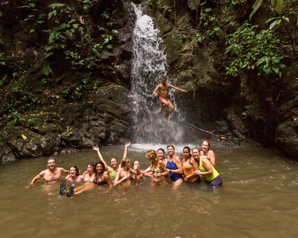 Group enjoying a waterfall, embodying adventure and natural revitalization at a Bali retreat. This image might show Parlatuvier Waterfall