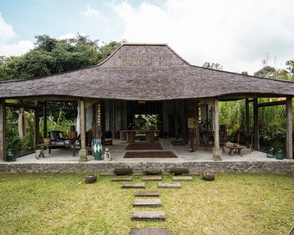 spacious yoga retreat venue surrounded by lush greenery in Bali, with a traditional Balinese design and open floor plan.