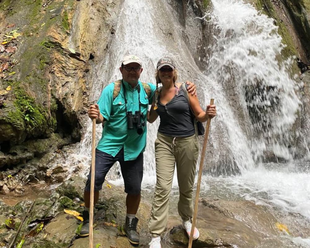 Couple hiking near waterfall, symbolizing adventure and natural rejuvenation at a Bali retreat