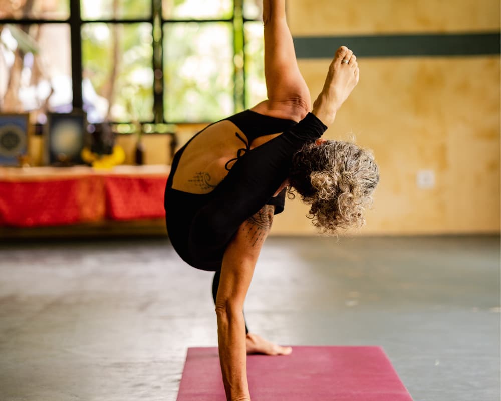 n instructor provides hands-on assistance during a yoga session, emphasizing the personalized guidance available at a Bali retreat to deepen your practice and enhance physical well-being