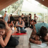 Group of yoga trainees seated on mats, writing notes during a workshop in Bali