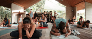 Group of yoga trainees seated on mats, writing notes during a workshop in Bali