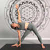 Extended Triangle Pose (Utthita Trikonasana) demonstrated by a flexible and experience female yoga teacher.