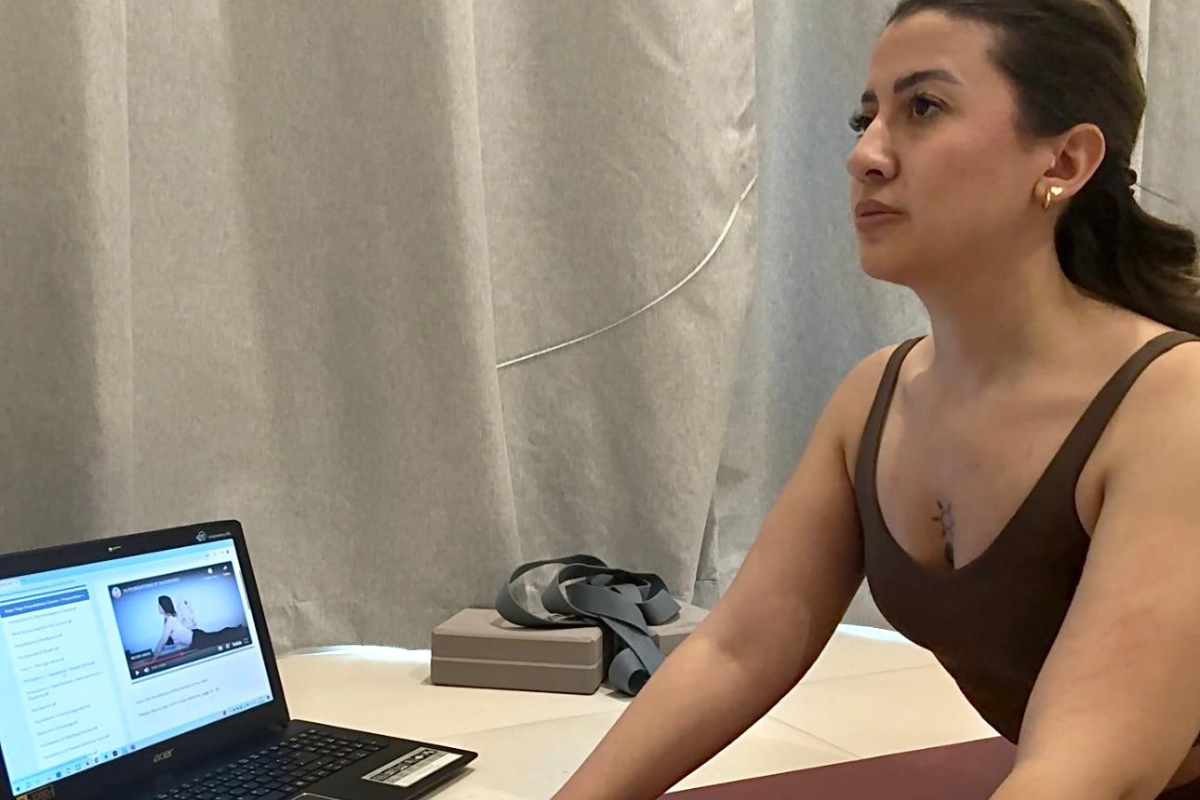 Me Focused attending an online class from home, following a teacher’s guidance on laptop while in a pose on my mat. A calm and dedicated moment of practice. Kaya yoga therapy 200-hour online ytt review: My honest experience & what you should know