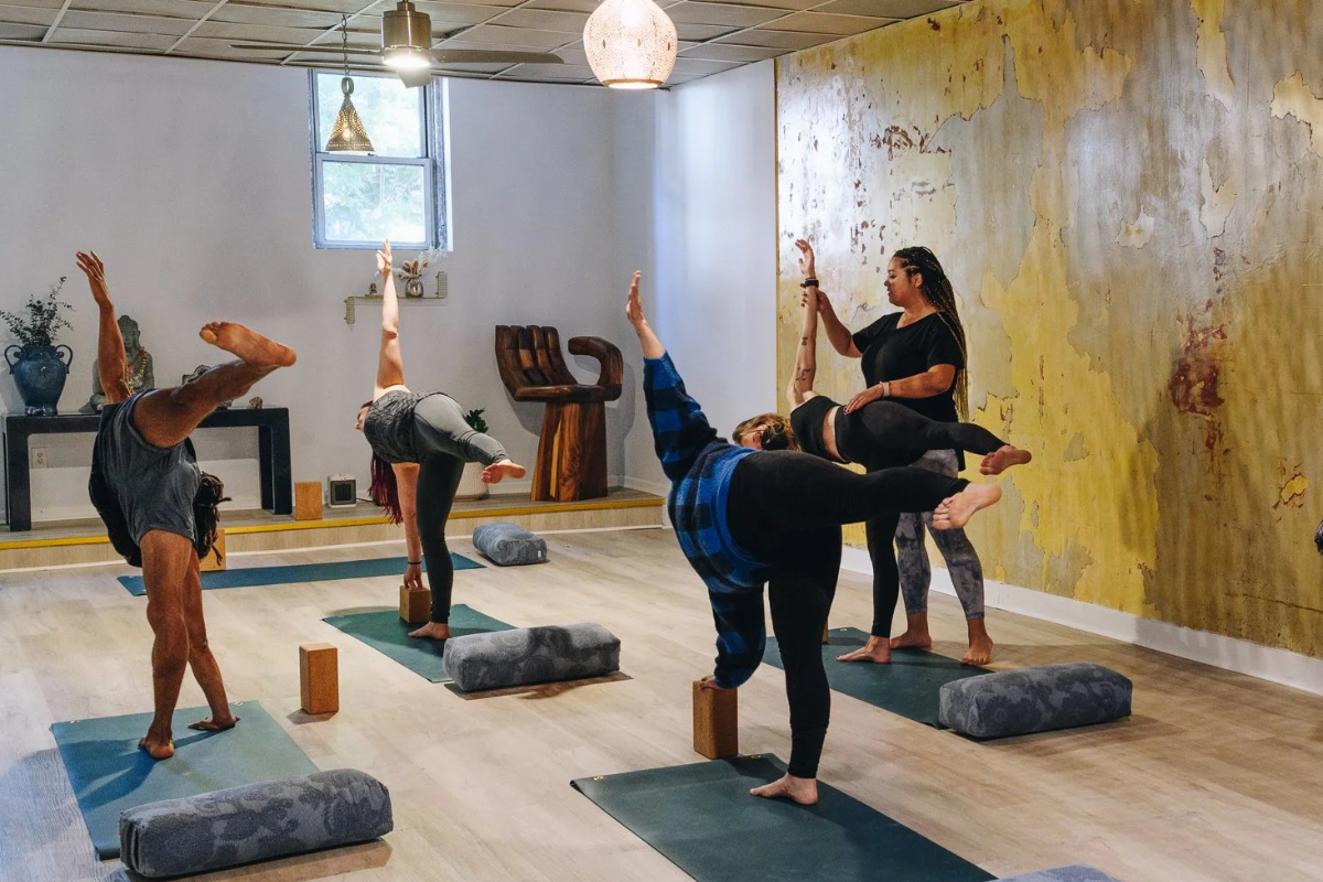 Students practicing yoga with instructor support at SPARŚA Brooklyn in Williamsburg and Greenpoint.
