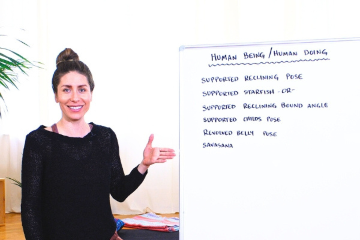 Yoga teacher presenting a restorative yoga sequence focused on relaxation and nervous system support