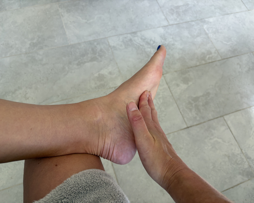 Applying OM Botanical magnesium body lotion to arm for hydration and skin nourishment