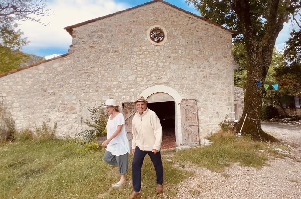 Berté et Carina se tiennent devant la chapelle en pierre de la Ferme Saint Pierre, à Bargème. Cette photo met en valeur les propriétaires du domaine ainsi que l’un des bâtiments les plus emblématiques du lieu, au cœur du Haut Var.