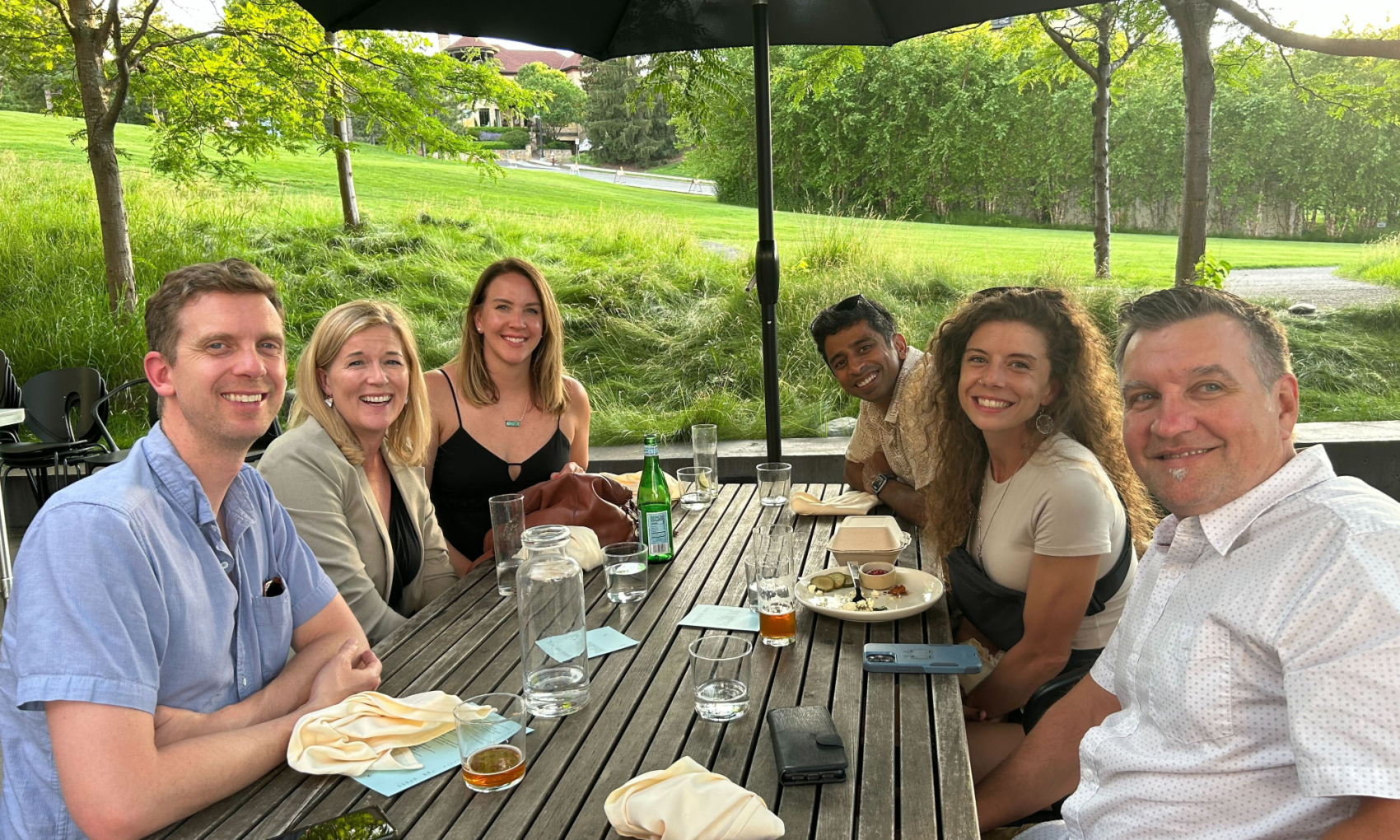 OfferingTree team members seated outdoors at a lunch table during a casual team gathering.