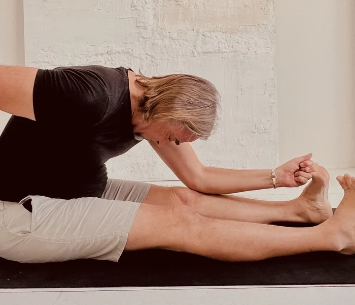 Man holding his lower back illustrating back pain after yoga and chronic lower back discomfort