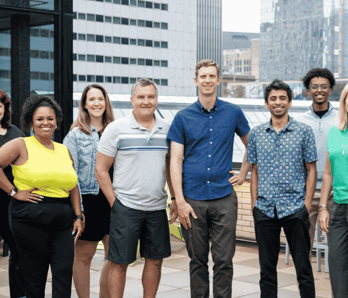 The OfferingTree team, including co-founders Chris Appiah, Alex Haley, and Tom McCook, standing together at the company's headquarters.