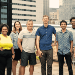 The OfferingTree team, including co-founders Chris Appiah, Alex Haley, and Tom McCook, standing together at the company's headquarters.