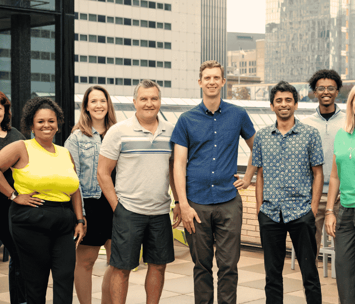 The OfferingTree team, including co-founders Chris Appiah, Alex Haley, and Tom McCook, standing together at the company's headquarters.